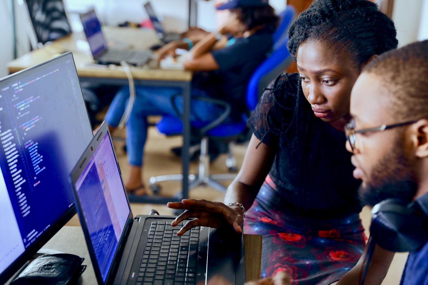 Équipe africaine travaillant sur du code dans un bureau moderne