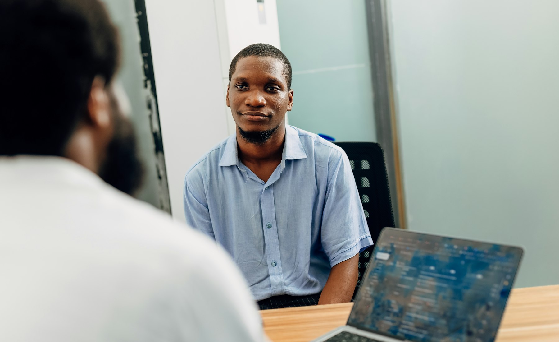 Professionnel africain en réunion devant un ordinateur portable, à Lagos